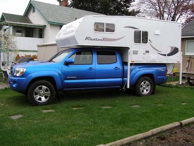 The Westland RV Travelaire 7.6 Mid-Size Truck Camper parked on a front lawn in BC