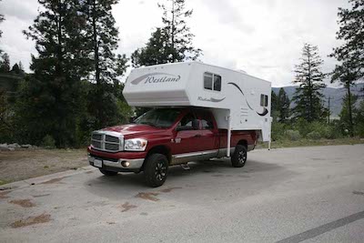 The Westland RV Travelaire 90W Truck Camper parked on a remote road overlooking mountains in BC 