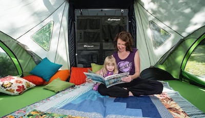 A mother and daughter reading a book in the SylvanSport GO with a hanging organizer in the background