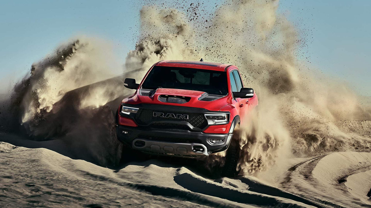 Red 2021 Ram 1500 TRX blasting through a sand dune