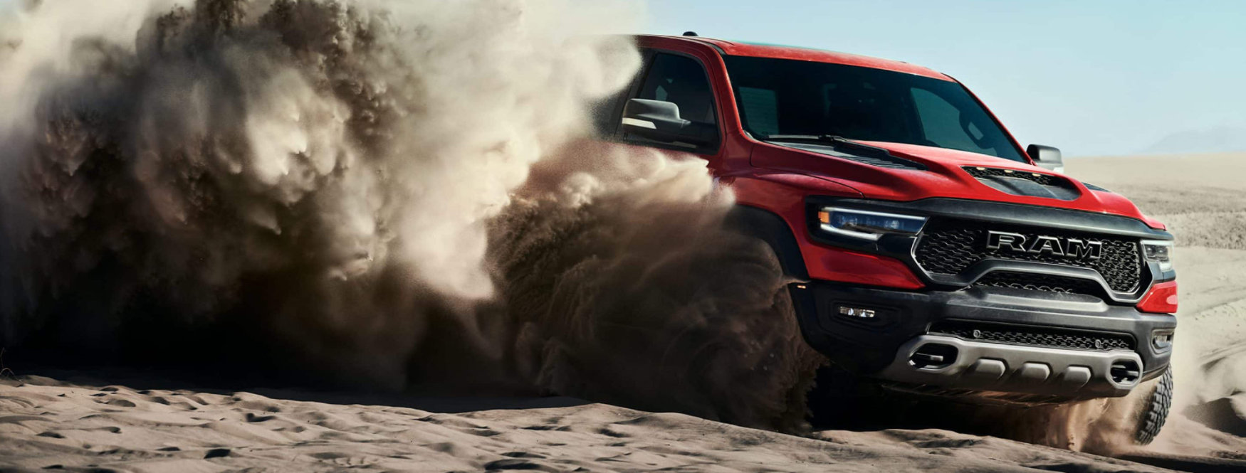 2021 red Ram 1500 TRX racing across sandy dunes