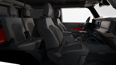 Interior view of the 2022 Bronco Wildtrak, with black leather seats, dash, and driver-side window displayed.