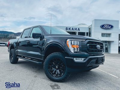 A black 2022 Ford F-150 XLT parked at the Skaha Ford dealership in Penticton, BC.