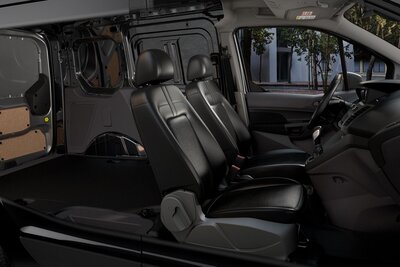 Interior view of the 2022 Ford Transit Connect, with black leather seats and customized rear bay visible.